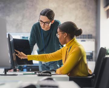 staff helping a coworker at computer