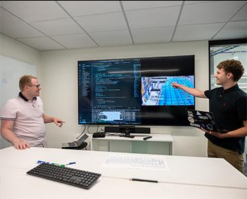 student working in front of large screen